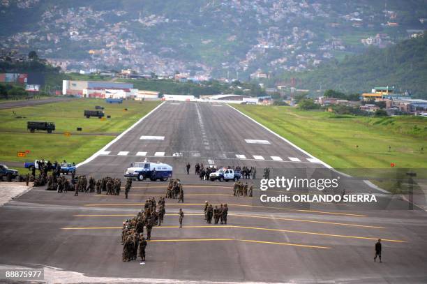 Military vehicles and soldiers block the runway to prevent the landing of the Venezuelan airplane carrying ousted Honduran President Manuel Zelaya at...