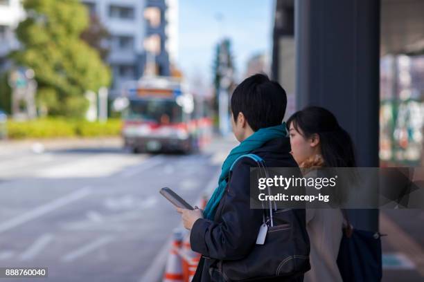 two businesswomen waiting for bus - shuttle bus stock pictures, royalty-free photos & images