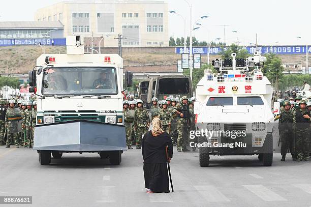 Uighur woman protests in front of policemen and riot vehicles on July 7, 2009 in Urumqi, the capital of Xinjiang Uighur autonomous region, China....