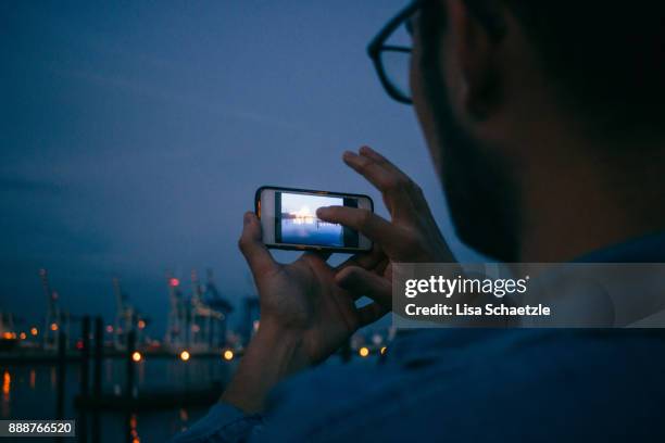 man takes a picture of the jetty in hamburg at night - die letzte reise photo call in hamburg stock-fotos und bilder