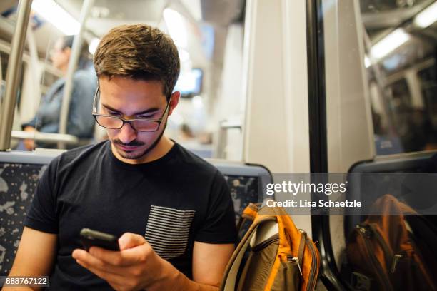 a man takes the subway watching his smartphone - metro hamburg stock pictures, royalty-free photos & images