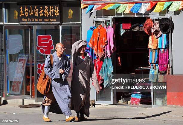 To go with AFP story by Robert J. Saijet: CHINA-RELIGION-BUDDHISM Buddhist monks walk past retail shops catering to tourism at Wutaishan on June 24,...