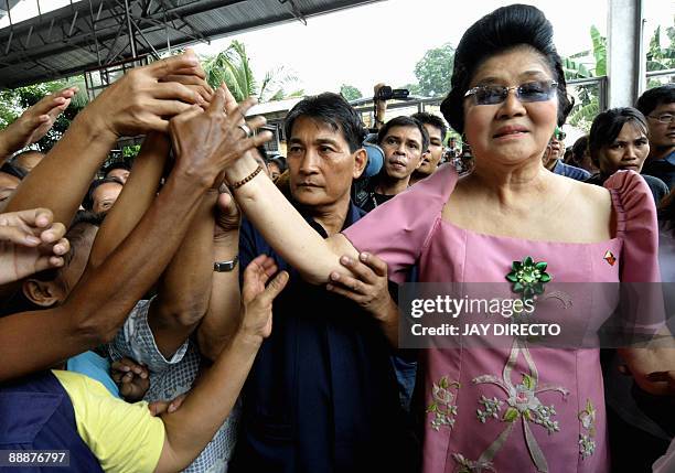 Flamboyant former first lady Imelda Marcos is greeted by supporters as she arrives in the suburban Payatas district, north of Manila to distribute...