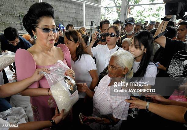 Flamboyant former first lady Imelda Marcos is greeted by supporters as she arrives in the suburban Payatas district, north of Manila to distribute...