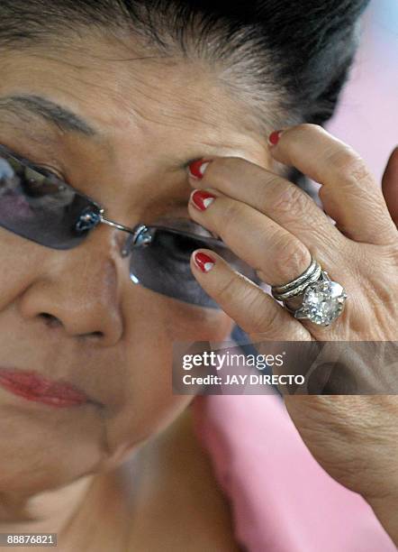 Former first lady Imelda Marcos speaks as she arrives in suburban Payatas district north of Manila to distribute rice to hundreds of poor families on...