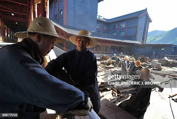 To go with AFP story by Robert J. Saijet: CHINA-RELIGION-BUDDHISM Buddhist nuns work together in a chain-gang style transferring wooden planks during...