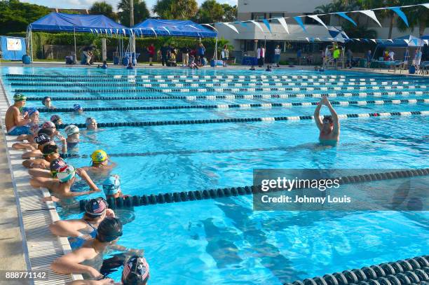 Ryan Lochte working on stroke definition with teens and babies who learned to swim through Baby Otter at Central Park Aquatic Complex on December 03,...