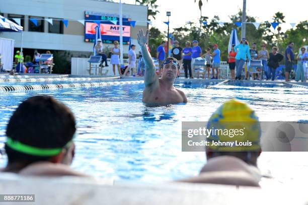 Ryan Lochte working on stroke definition with teens and babies who learned to swim through Baby Otter at Central Park Aquatic Complex on December 03,...