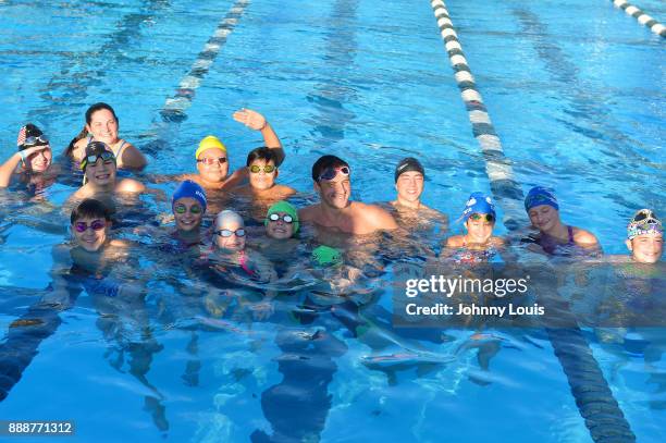 Ryan Lochte working on stroke definition with teens and babies who learned to swim through Baby Otter at Central Park Aquatic Complex on December 03,...