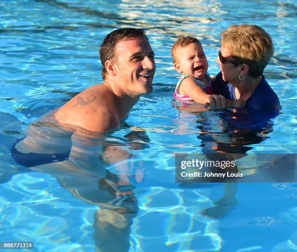 Ryan Lochte working on stroke definition with teens and babies who learned to swim through Baby Otter at Central Park Aquatic Complex on December 03,...