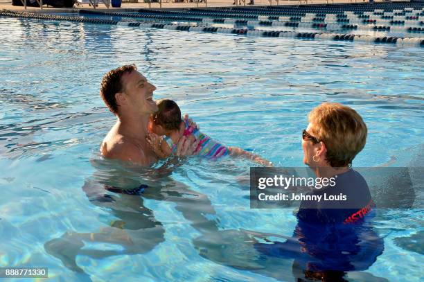 Ryan Lochte working on stroke definition with teens and babies who learned to swim through Baby Otter at Central Park Aquatic Complex on December 03,...