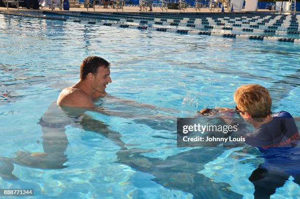 Ryan Lochte working on stroke definition with teens and babies who learned to swim through Baby Otter at Central Park Aquatic Complex on December 03,...