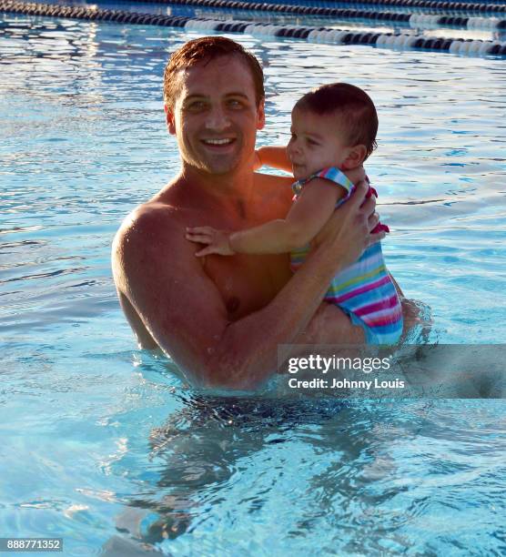 Ryan Lochte working on stroke definition with teens and babies who learned to swim through Baby Otter at Central Park Aquatic Complex on December 03,...