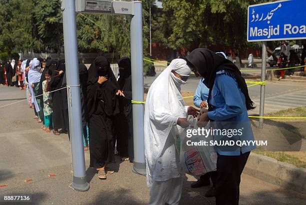 Pakistani policewoman conducts a security check outside the Red Mosque in Islamabad on July 7, 2009. More than 1,000 Islamist hardliners gathered...