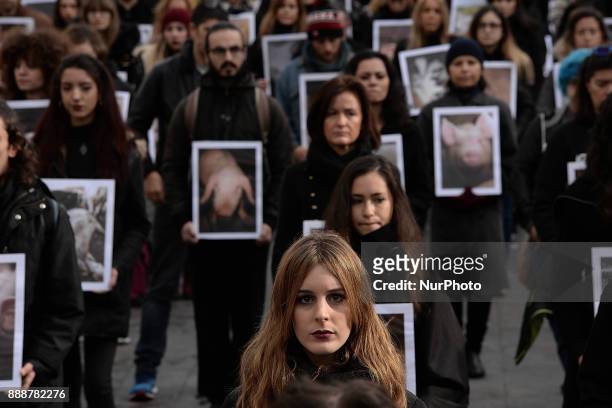Animal rights activists from hold up pictures of animals they say are mistreated during a demonstration in Madrid on 9 th December, 2017.