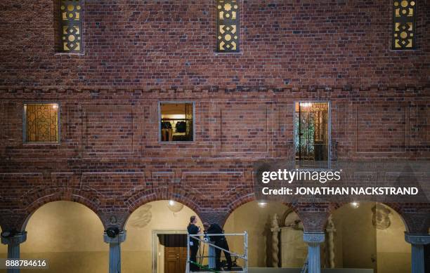 Men work at Stockholm city hall, where preparations are under way for the 2017 Nobel Banquet on December 7, 2017. / AFP PHOTO / Jonathan NACKSTRAND