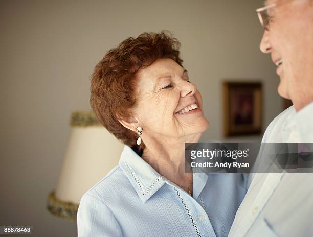 senior couple smiling, enjoying each other - leanintogether stock pictures, royalty-free photos & images