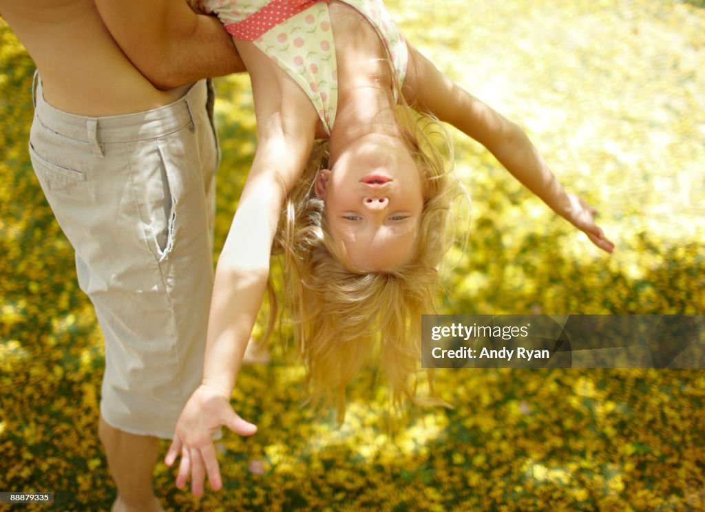 Girl playing in her father's arms.