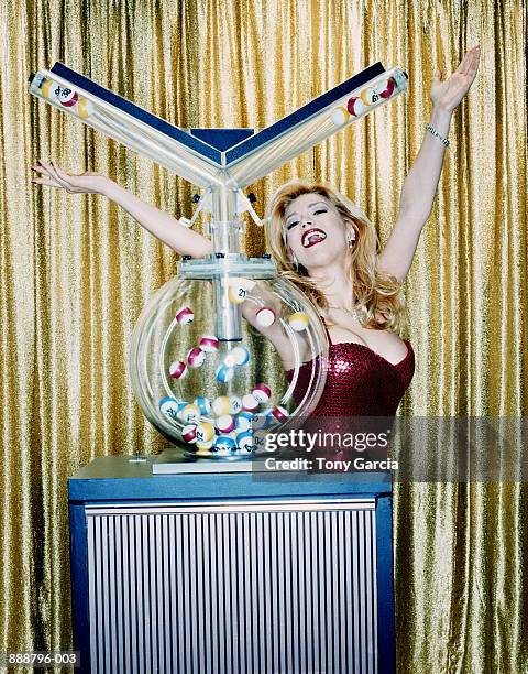 female host raising arms beside lottery machine (cross-processed) - loto photos et images de collection