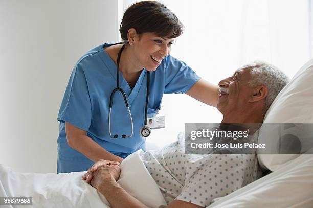 nurse with elderly male patient - adult male hospital bed stock-fotos und bilder