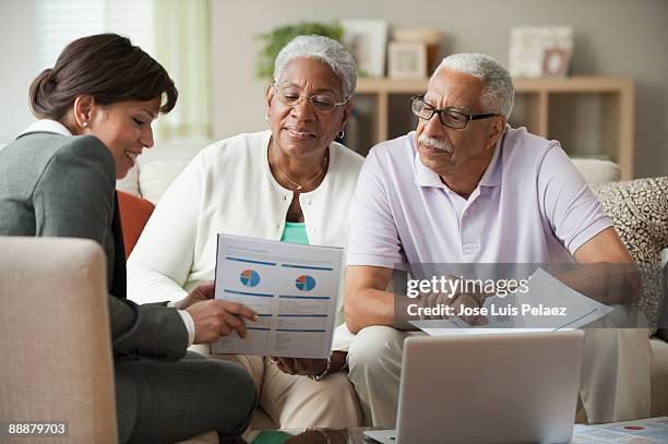 elderly couple receiving financial consultation - elderly receiving paperwork stock pictures, royalty-free photos & images