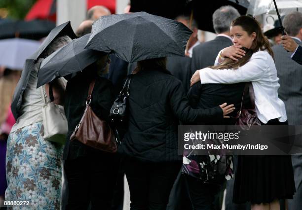 Mourners console one another as they attend the unveiling of the July 7 bombings memorial service at Hyde Park on July 7, 2009 in London, England....