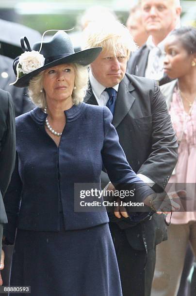 Camilla, Duchess of Cornwall and Boris Johnson stand in the rain during the unveiling of the July 7 bombings memorial service at Hyde Park on July 7,...