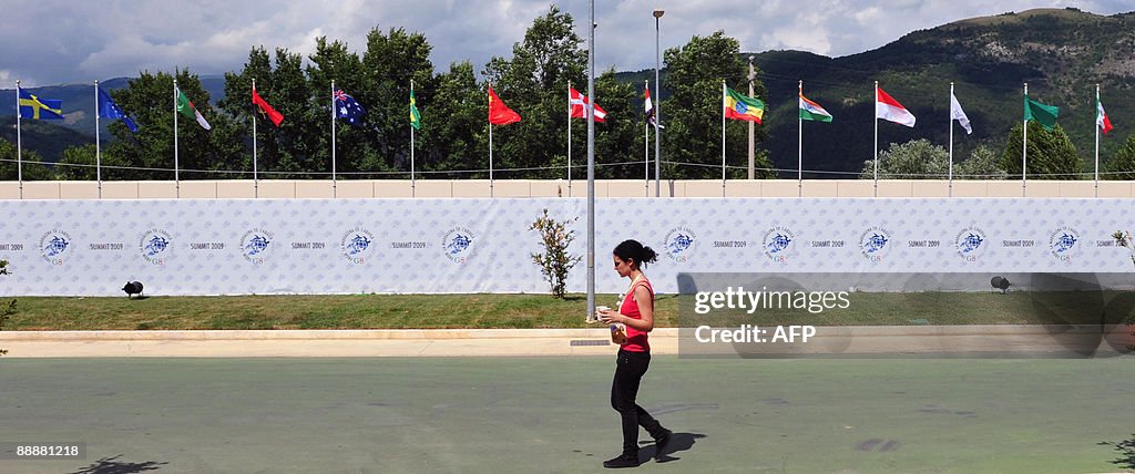 A journalist walks past flags of the cou