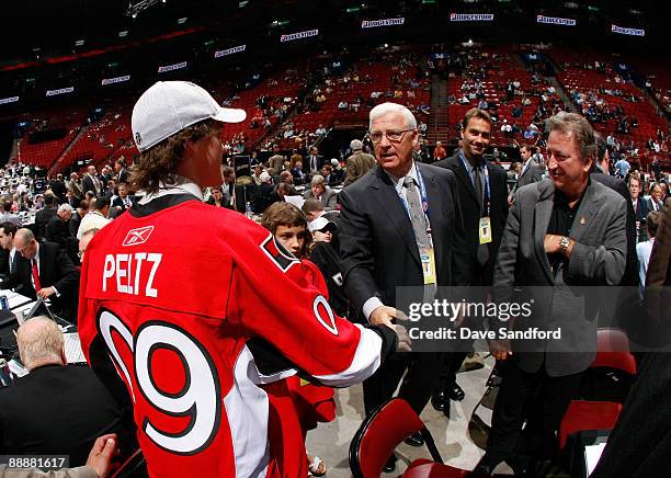 Brad Peltz shakes the hand of General Manager Bryan Murray of the Ottawa Senators organization after being drafted in the second day of the 2009 NHL...