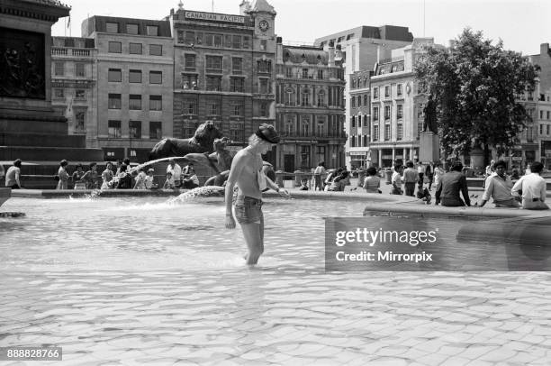 Heatwave in Trafalgar Square, London. As the temperatures soared into the 80s again today, the cool fountains in Trafalgar Square were even more...