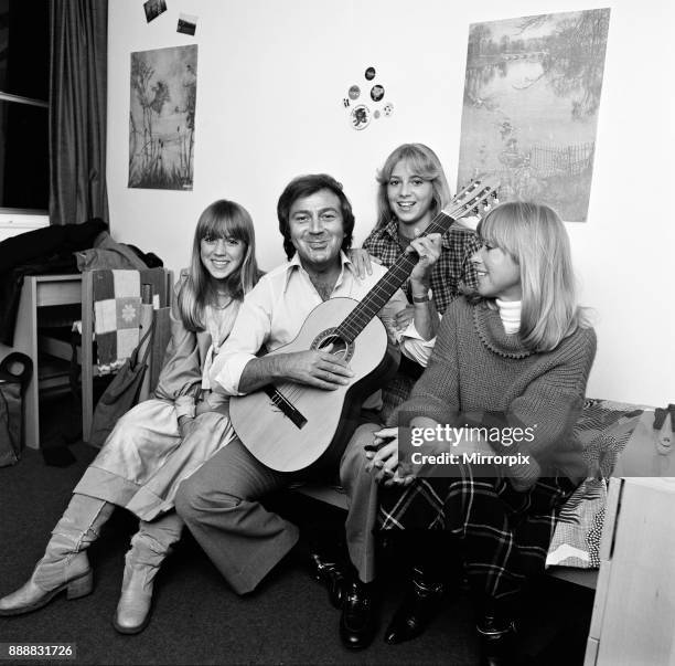 Des O'Connor playing guitar at home with his daughters Tracy and Samantha and wife Gillian, 7th February 1978.
