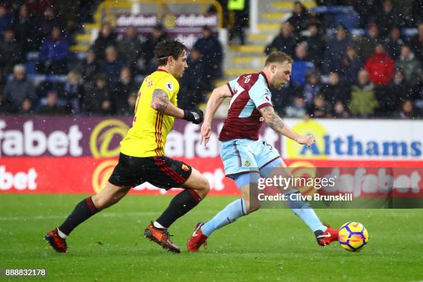 Scott Arfield of Burnley scores his sides first goal while under pressure from Daryl Janmaat of Watford during the Premier League match between...