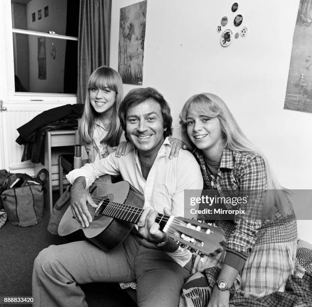 Des O'Connor playing guitar at home with his daughters Samantha and Tracy, 7th February 1978.