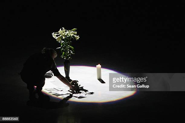 Woman places flowers at a spot-lit candle at the O2 Arena where fans of late U.S. Pop-star Michael Jackson watched a live broadcast of Jackson's...