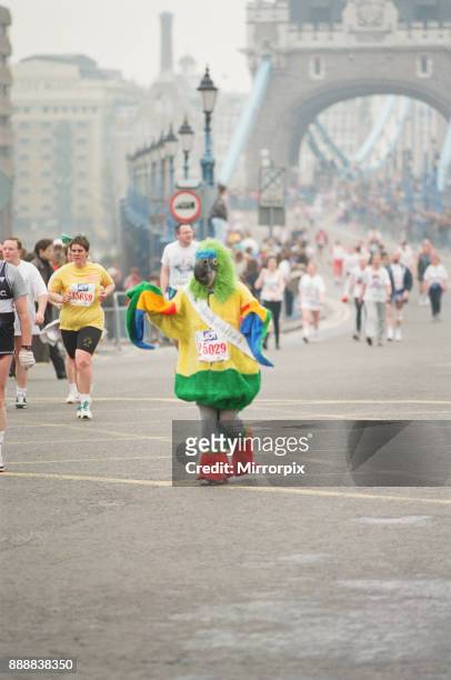 The London Marathon - 1990 Runners pass through and around the Tower Bridge area. Run funnies. A runner dressed as a perroquet bird, picture taken...