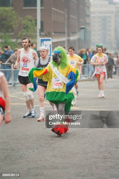 The London Marathon - 1990 Runners pass through and around the Tower Bridge area. Run funnies. A runner dressed as a perroquet bird, picture taken...