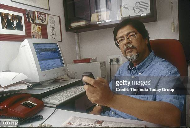 Chandan Mitra, Editor-in-chief, The Pioneer Group sitting in his office with cellphone and PC