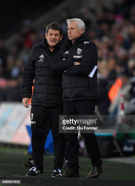 Manager Alan Pardew discusses tactics with assistant John Carver during the Premier League match between Swansea City and West Bromwich Albion at...