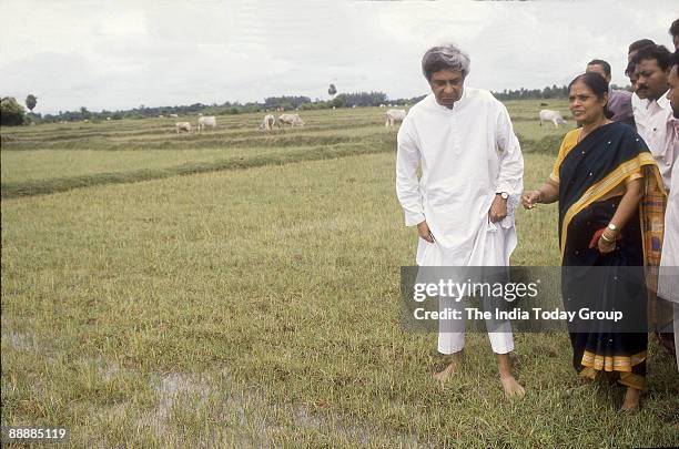 Naveen Patnaik, Chief Minister of Orissa standing with his partymen in paddy fields