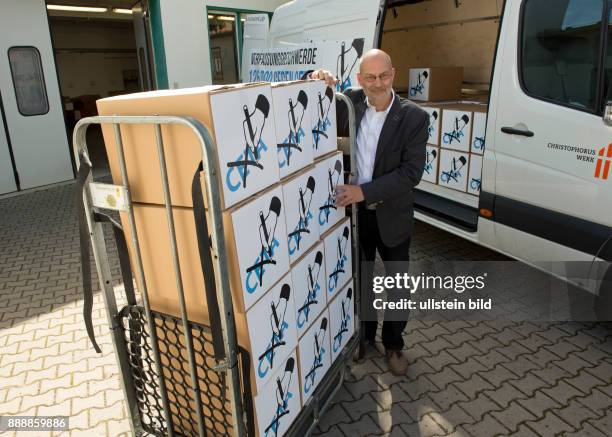 Ralf-Uwe Beck, Sprecher des Bundesvorstandes von "Mehr Demokratie", beim Christophoruswerk in Vieselbach bei Erfurt beim Verladen von Kartons mit...