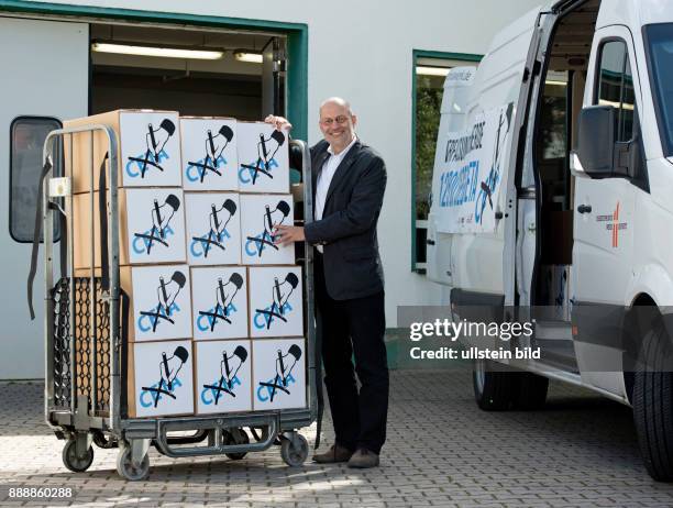 Ralf-Uwe Beck, Sprecher des Bundesvorstandes von "Mehr Demokratie", beim Christophoruswerk in Vieselbach bei Erfurt beim Verladen von Kartons mit...