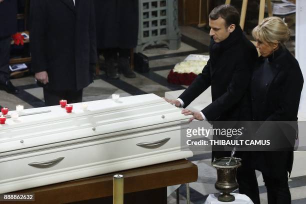 French President Emmanuel Macron and Brigitte Macron stand next to the coffin during the funeral ceremony for late French singer Johnny Hallyday at...
