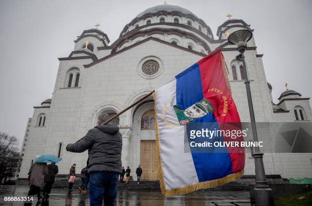 In this photograph taken on December 9 a Serbian nationalist holds a flag with an image of Bosnian Serb convicted war criminal Ratko Mladic, as he...
