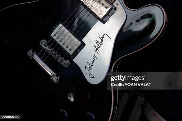 Guitar of late French singer Johnny Hallyday is on display by the Madeleine church during his funeral ceremony on December 9, 2017 in Paris. - French...