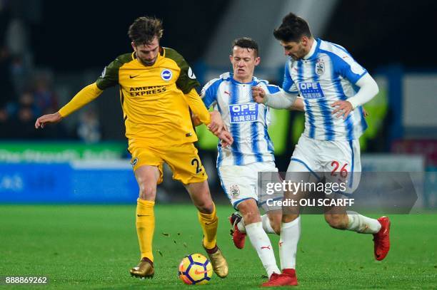 Brighton's Dutch midfielder Davy Propper runs with the ball pursued by Huddersfield Town's English midfielder Jonathan Hogg and Huddersfield Town's...