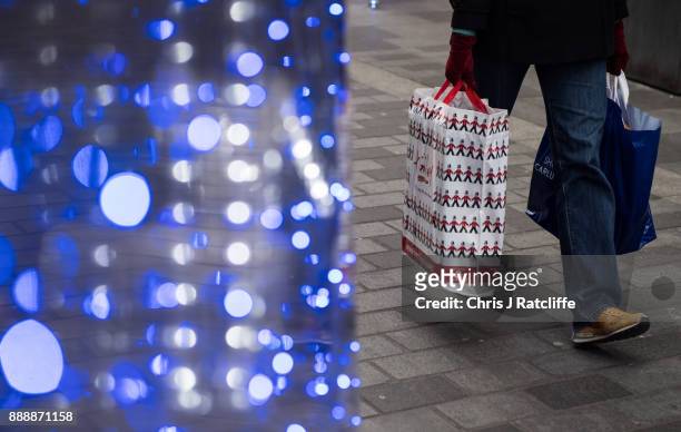 Shopper holds bags of purchases on South Molton Street on December 9, 2017 in London, England. With two weeks of shopping time left before Christmas,...
