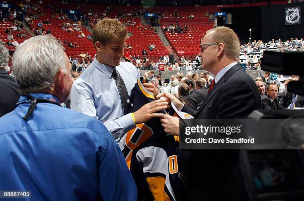 Marcus Foligno receives a Buffalo Sabres jersey from General Manager Darcy Regier of the Buffalo Sabres after being drafted during the second day of...