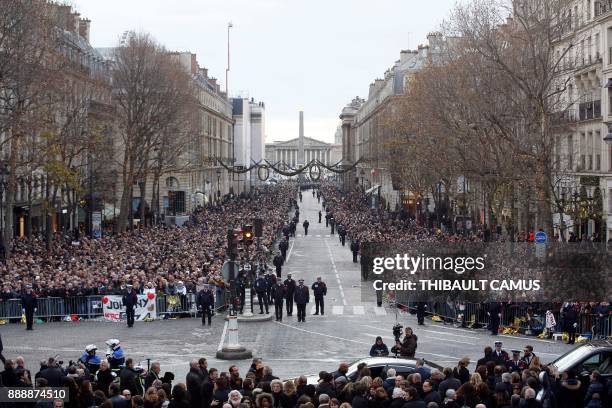 Mourners are gathered in front of the La Madeleine Church ahead of the funeral ceremony in tribute to the late French singer Johnny Hallyday in Paris...