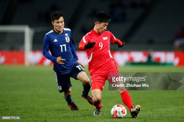 Konno Yasuyuki of Japan and Pak Myong Song of North Korea in action during the EAFF E-1 Men's Football Championship between Japan and North Korea at...