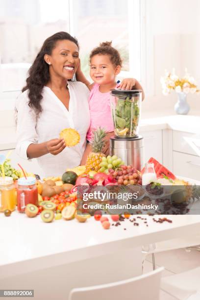 mother with daughter 2-3 years age making fruit juices at kitchen. - mint plant family stock pictures, royalty-free photos & images